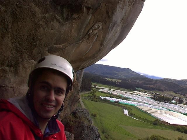 Climber with helmet under a rock roof in Suesca