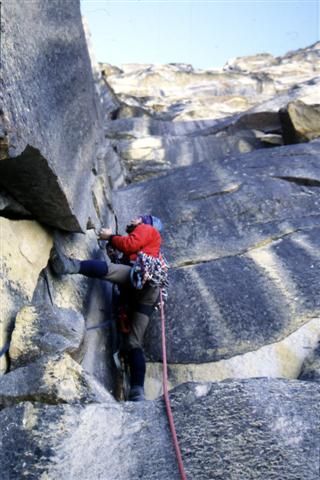 Climber on the grey slab, alpine setting